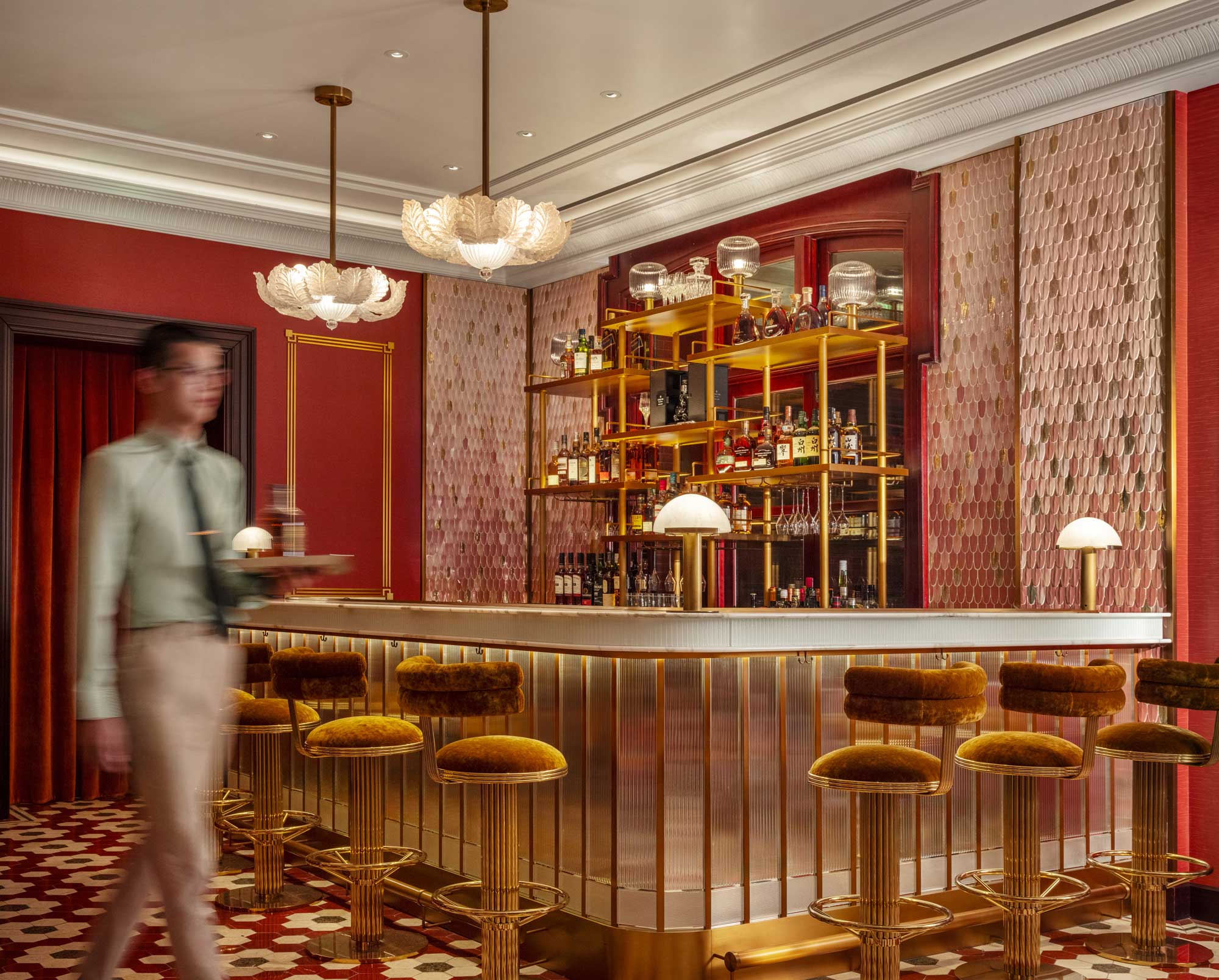 Elegant Art Deco bar interior at Harrods Residence in Cha House Shanghai, with gold accents, plush bar stools, and a bartender serving cocktails.
