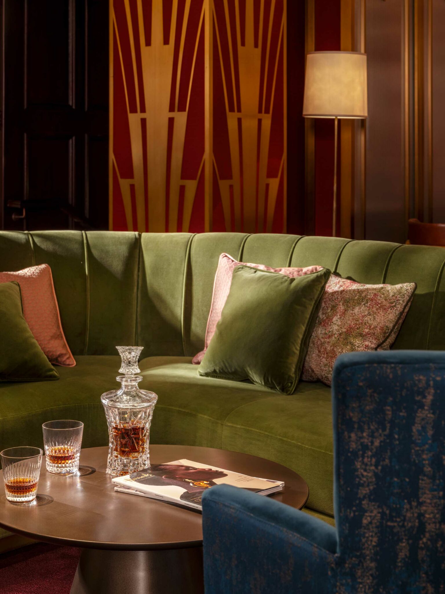 Luxury Harrods Residence lounge at Cha House Shanghai featuring a green velvet sofa, Art Deco wall panels, and a crystal whisky decanter on a bronze coffee table