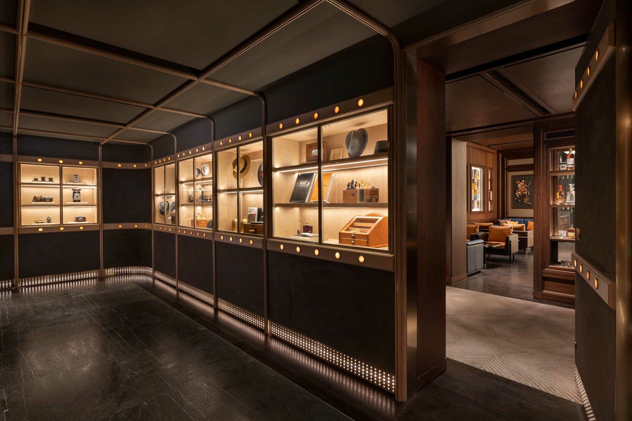 Arrival lobby of Apartment 208 at Park Hyatt Suzhou, designed as a hidden grand residence with illuminated display cases showcasing curated memorabilia, leading discreetly into the luxury bar and dining spaces.