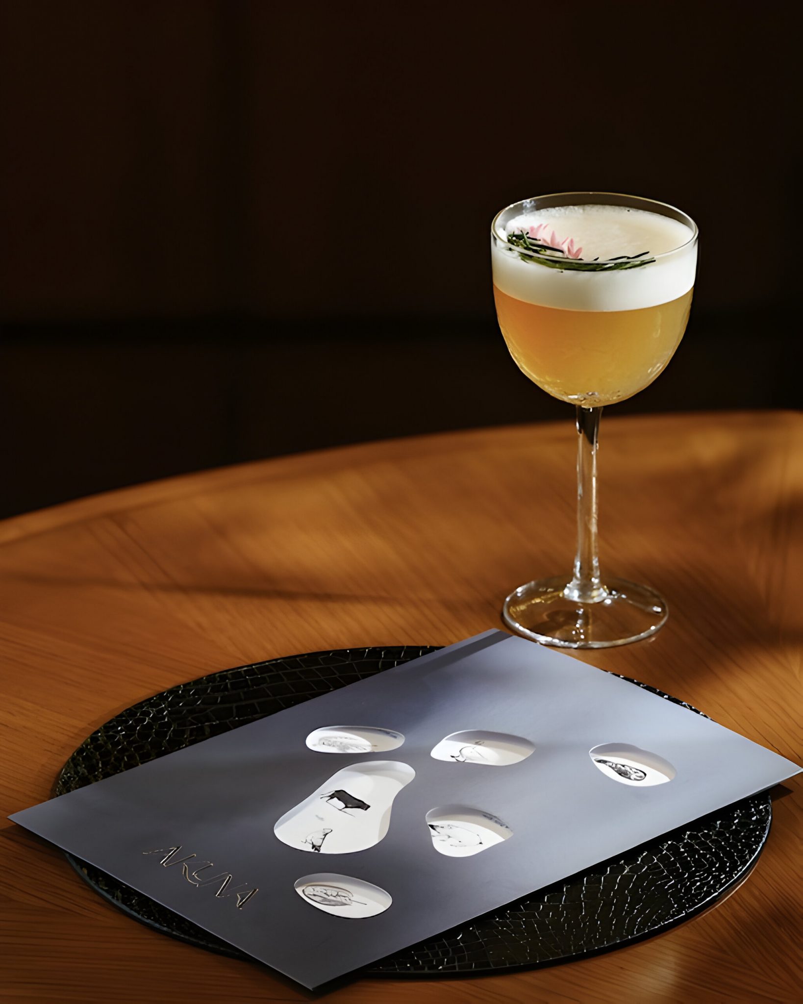 Akuna Restaurant menu design paired with a signature cocktail, showcasing refined graphic language and contemporary hospitality branding by Social F+B and HBA Graphics