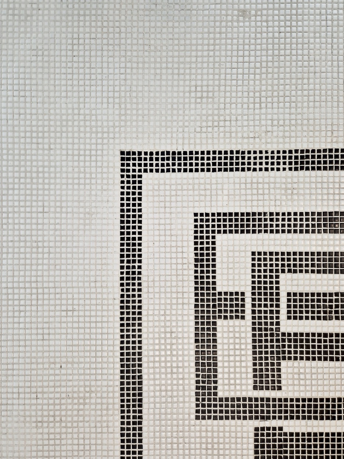 Close-up of mosaic tile flooring with the Butcher Box monogram pattern, illustrating Social F+B’s attention to branded materiality and detail in F&B retail design.