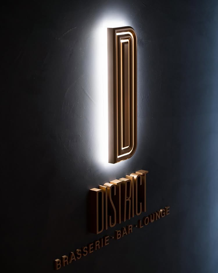 District brasserie, bar, and lounge logo signage at Kimpton Shinjuku Tokyo, showcasing the brand identity developed through concept creation and market research by Social F+B.