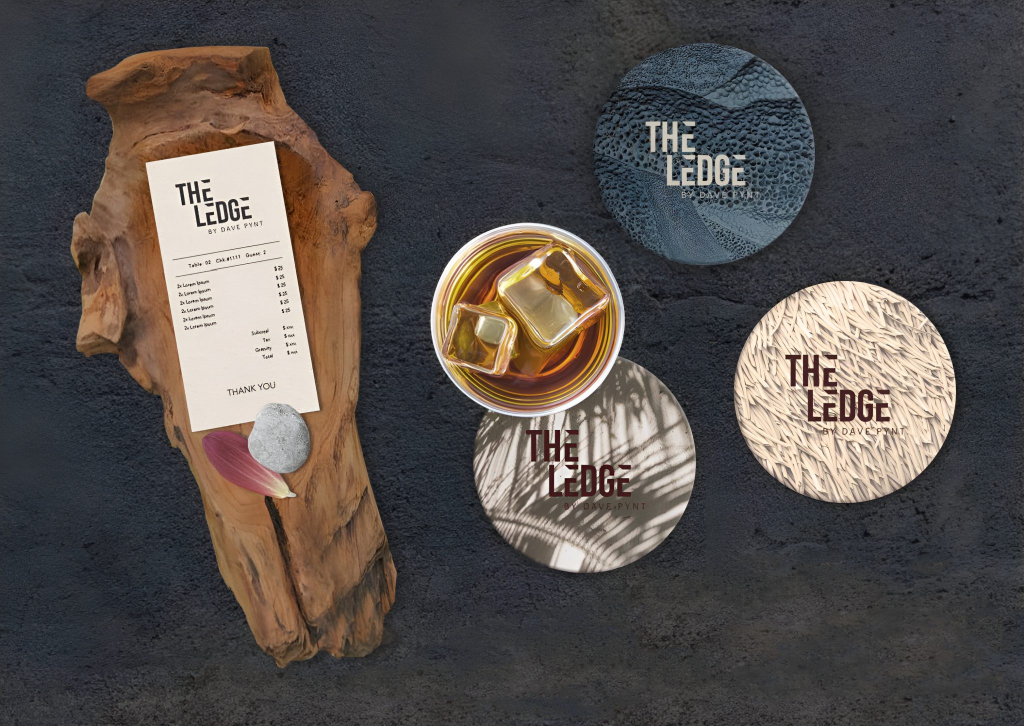 Branding collaterals for The Ledge by Dave Pynt at Waldorf Astoria Maldives, featuring a textured drinks coaster set, printed bill, natural wood presentation base, and cocktail styling that reflect the venue’s raw, nature-led design language.
