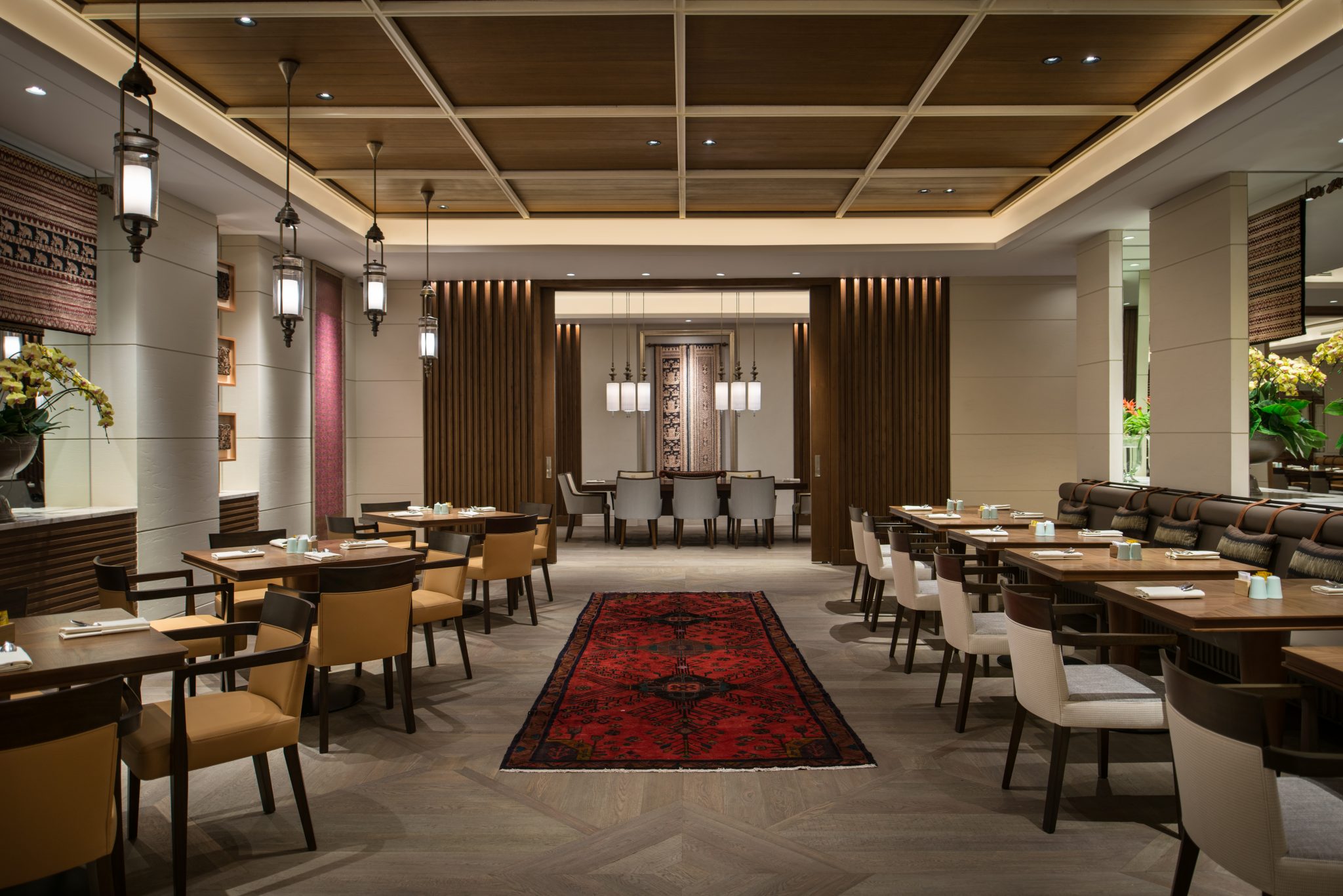 Dining area at Grand Café, Grand Hyatt Jakarta, highlighting a central art feature framed by timber detailing, warm lighting, and layered seating within an all-day dining setting designed by Social F+B