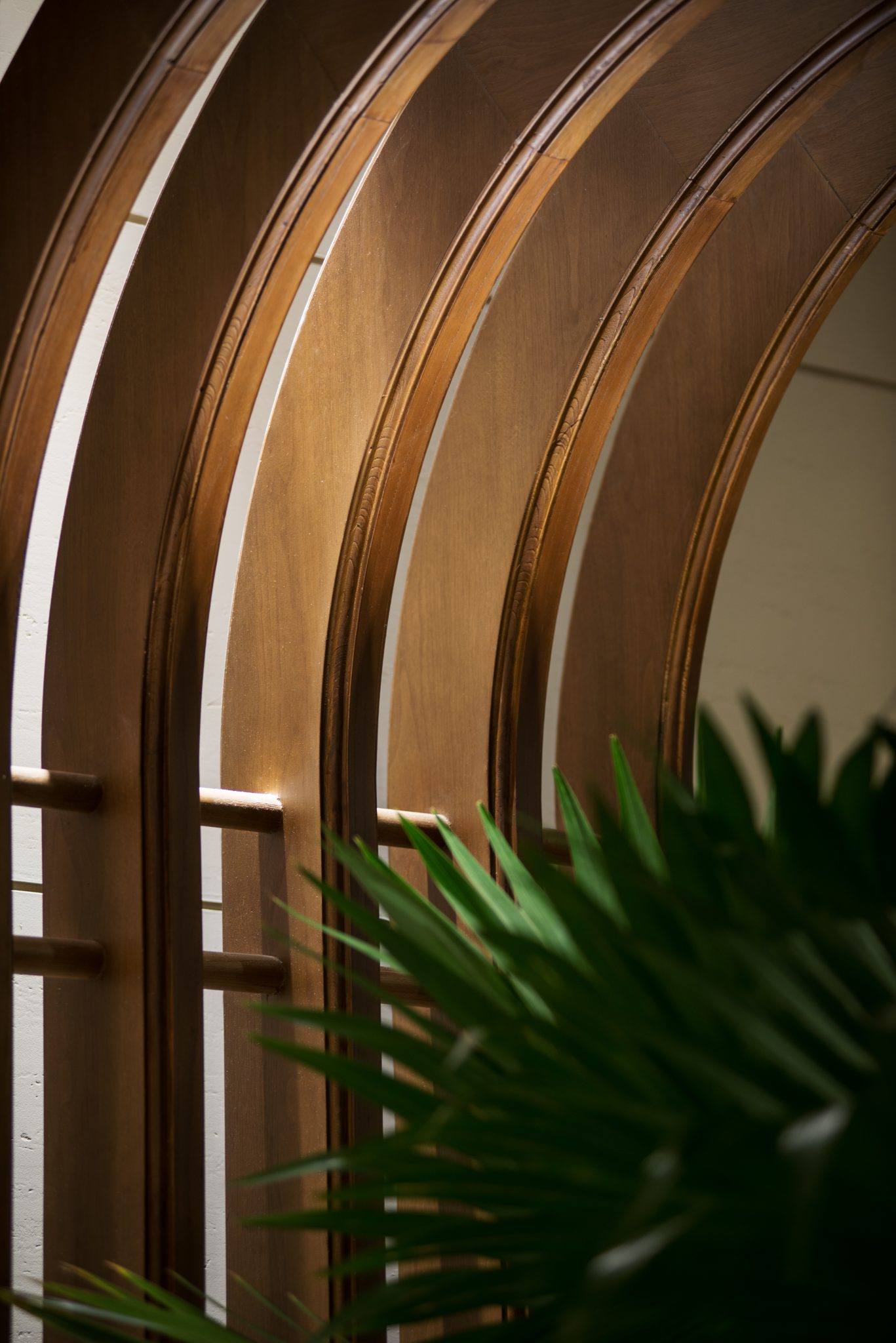 Close-up detail of curved timber architectural elements at Grand Café, Grand Hyatt Jakarta, highlighting warm wood tones, crafted joinery, and layered interior detailing designed by Social F+B